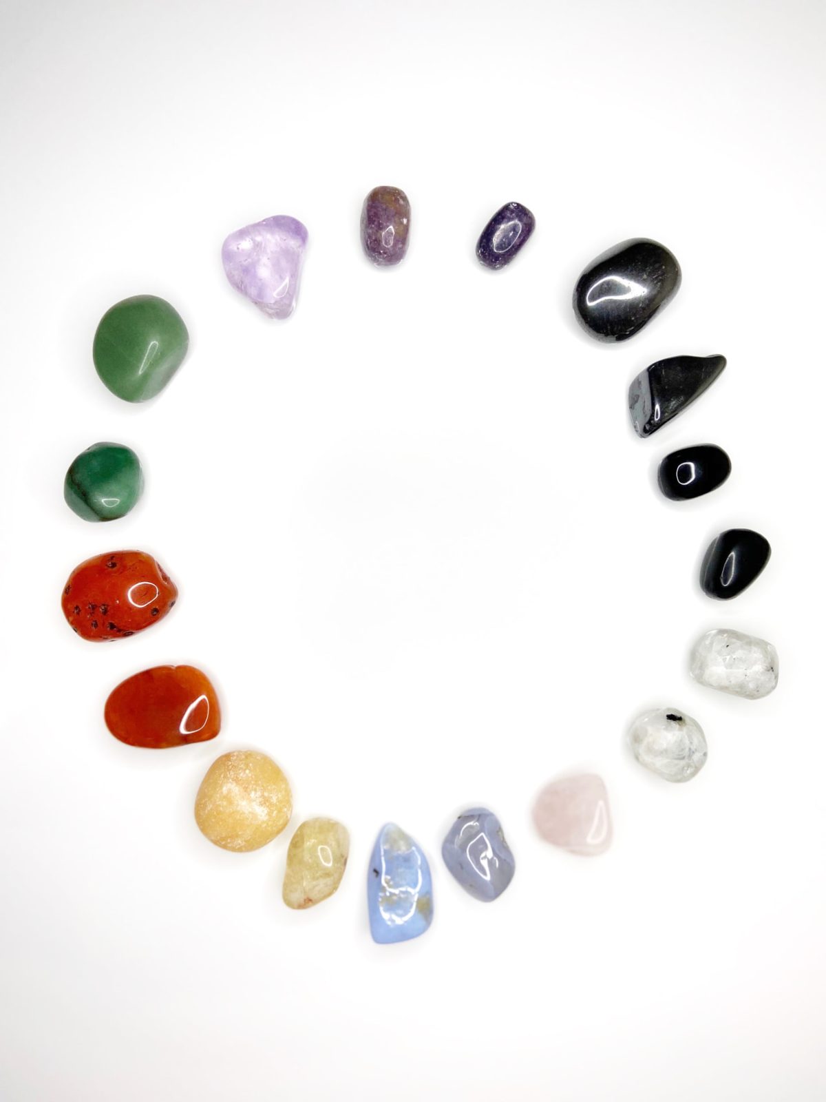 A circle of tumbled crystals in rainbow chakra colors