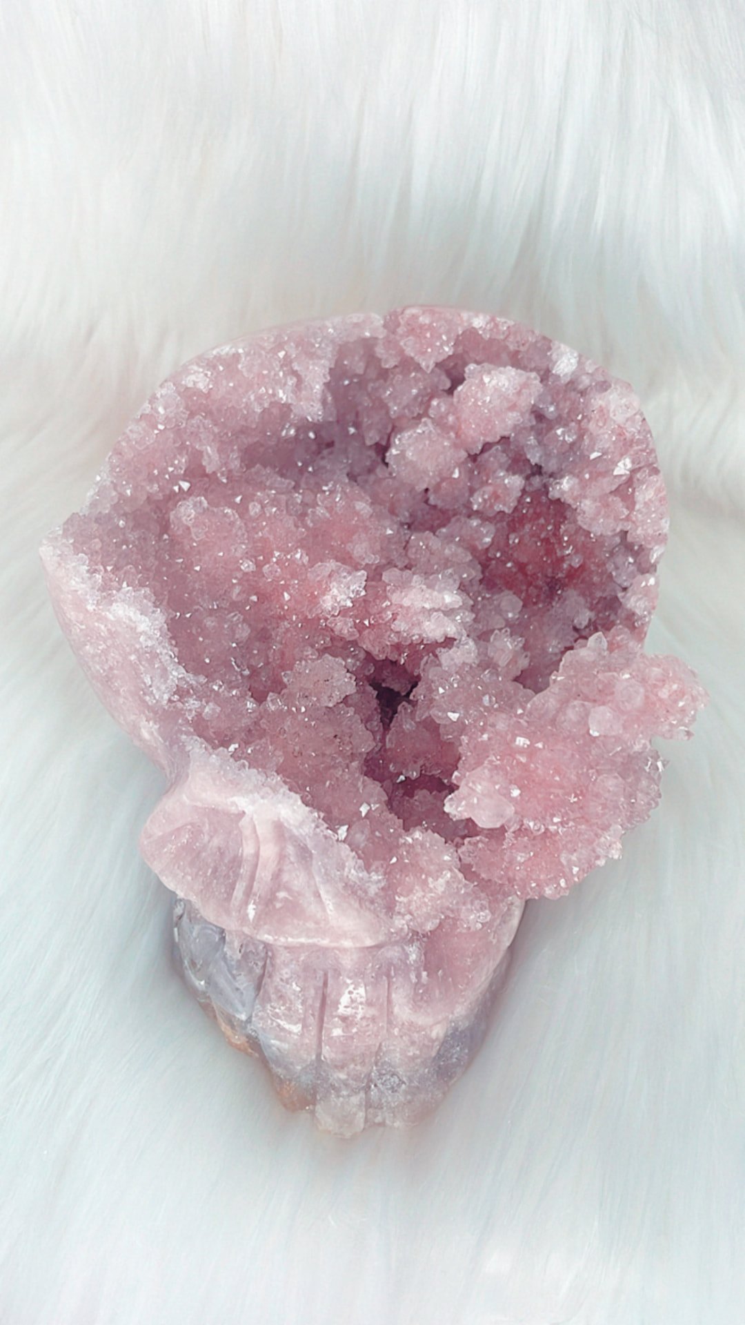 Pink amethyst druzy skull carving on white fur